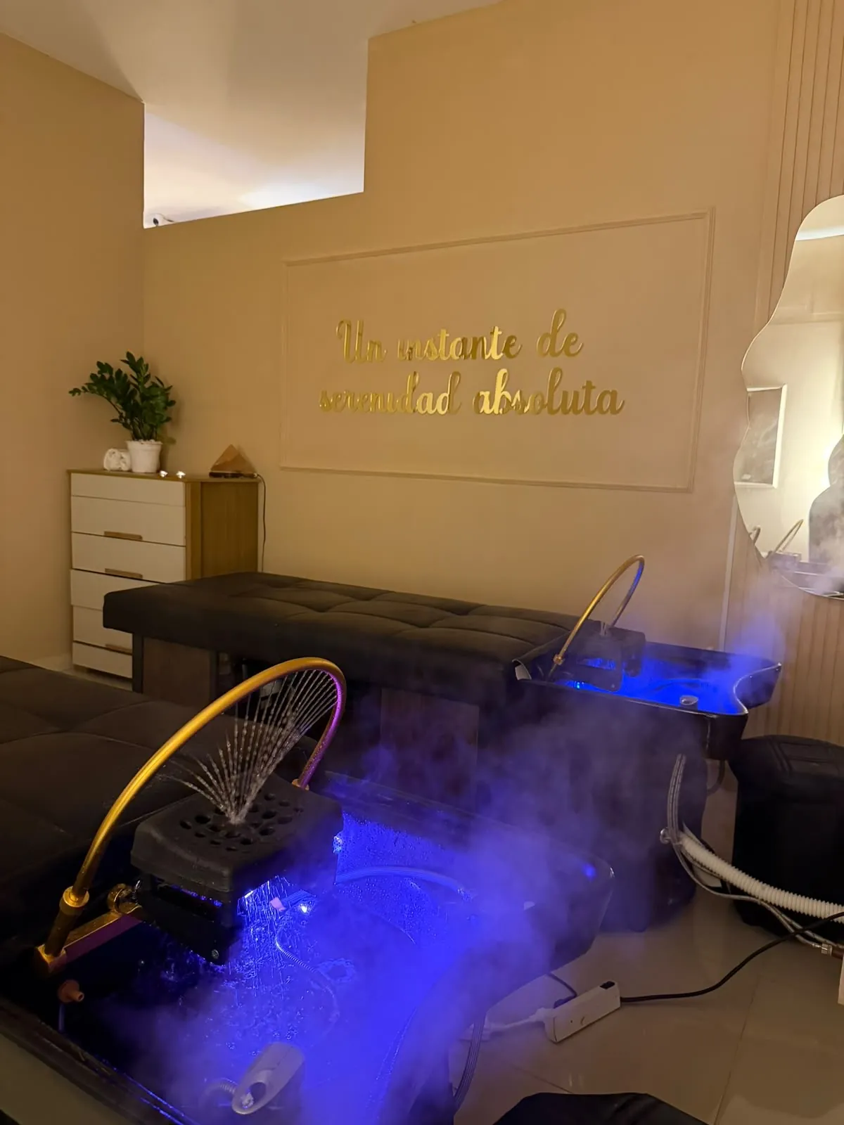 Sala de head spa a media luz, con vapor sobre el lavacabezas